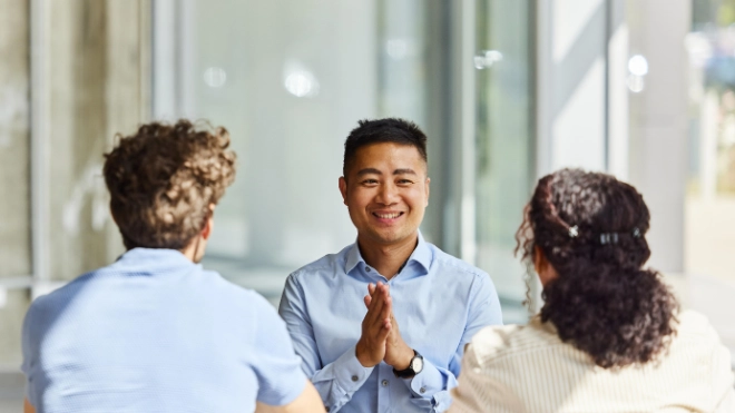 two men and woman talking at a table zoomed in