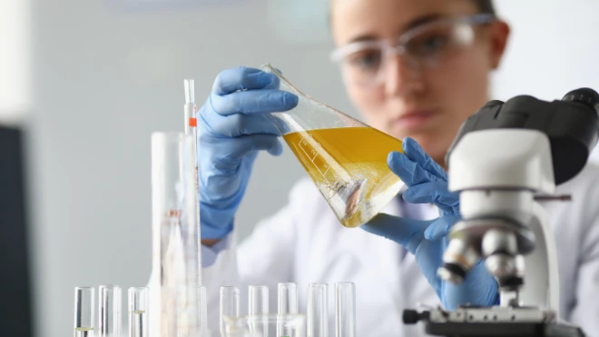 woman chemist scientist holding flask at hand