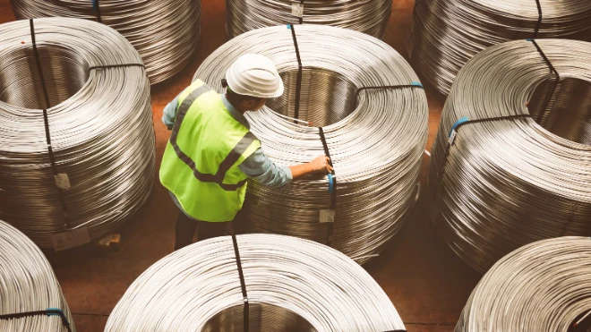 Male worker examining metal coils