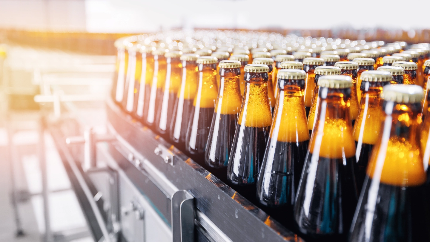 filled bottles lined up at a factory image