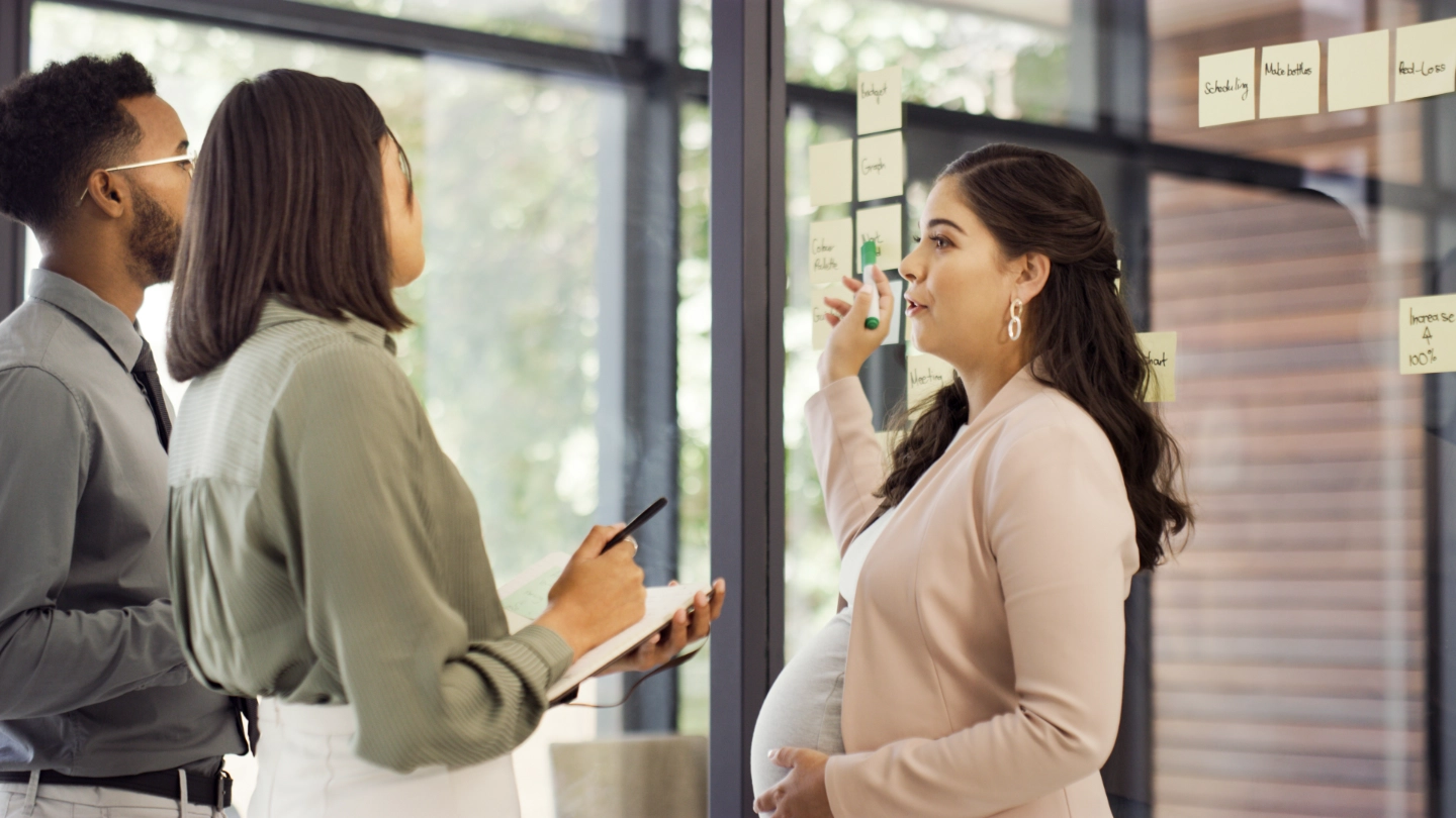 pregnant woman talking to woman and man image