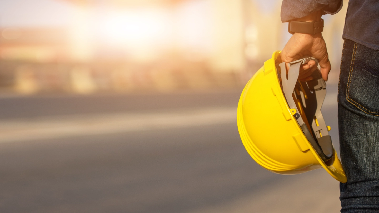 Construction worker holding safety helmet image