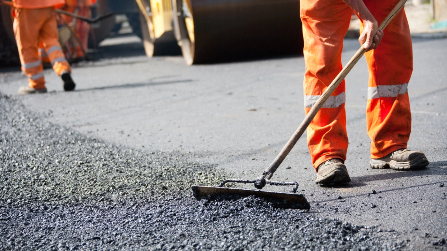 Construction workers laying tarmacadam roads image