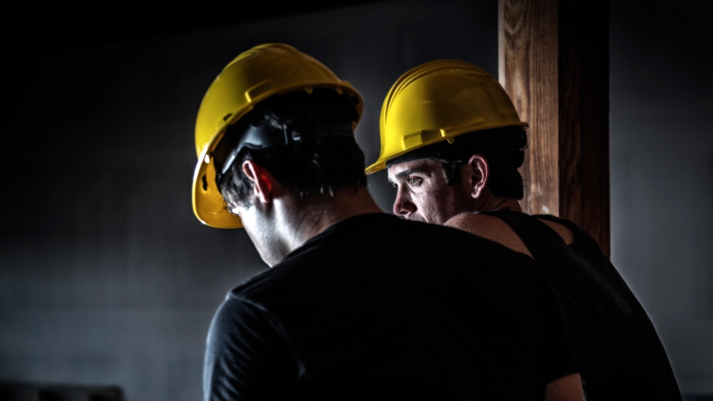 Two construction workers wearing yellow helmuts image